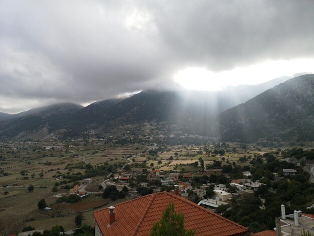 Aerial view of townscape and mountains against sky