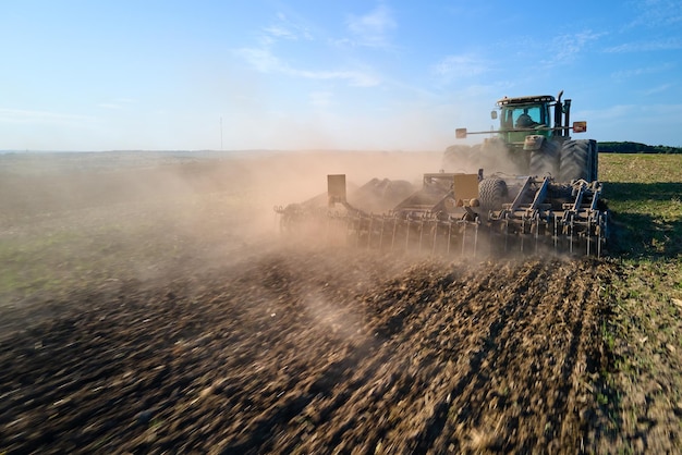 夏に播種するための土壌を準備する農業農地を耕すトラクターの航空写真