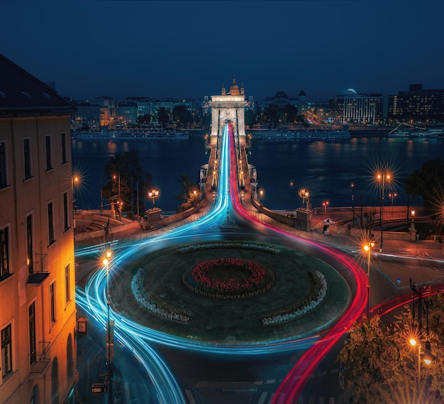 Photo aerial view of traffic at clark adam square roundabout with szechenyi chain bridge and danube river at night budapest hungary