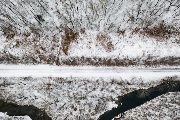 Aerial view of train line and river in winter