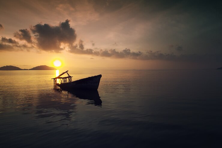 Aerial view of tropical island and old boat at sunset