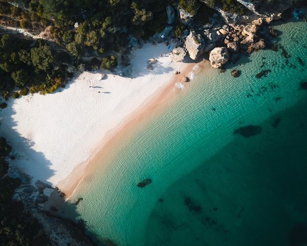 Vista aerea di una tranquilla spiaggia tropicale circondata da rocce