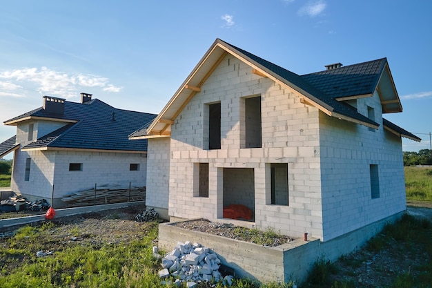 Photo aerial view of unfinished house with aerated lightweight concrete walls and wooden roof frame covered with metallic tiles under construction