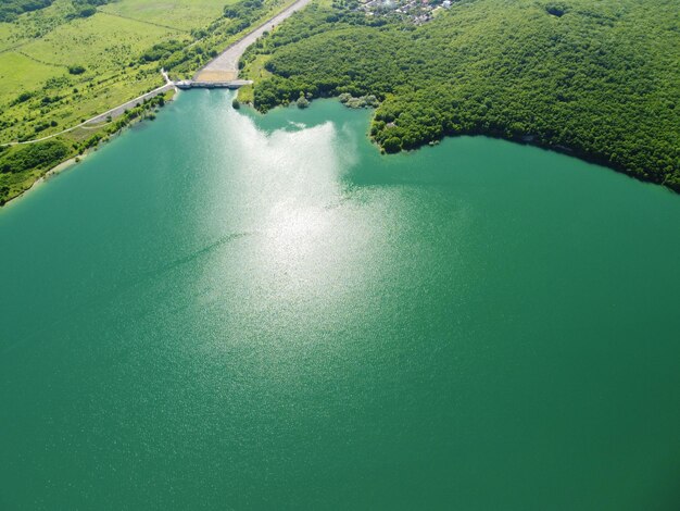 緑の春の森に覆われた山の谷の貯水池の空撮美しい景色