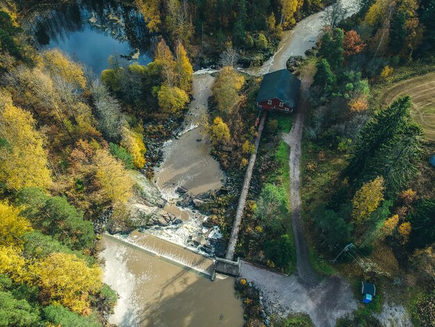 Вид с воздуха на водопад, речные пороги и древняя мельница. Фото взято из дрона. Финляндия, Порнайнен.