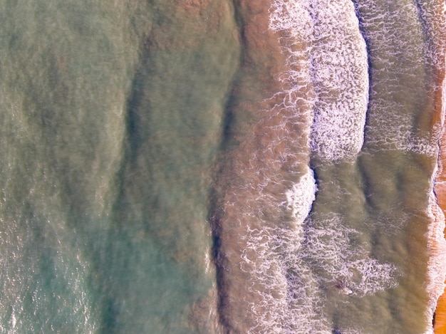 Photo aerial view of waves crashing on sandy shoresea surface ocean waves backgroundtop view beach background