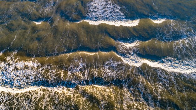 Onde di vista aerea sulla spiaggia di sabbia. onde del mare sulla bellissima vista aerea della spiaggia.