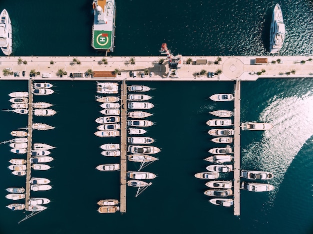 Vista aerea di yacht bianchi ormeggiati in file ordinate sul molo di porto