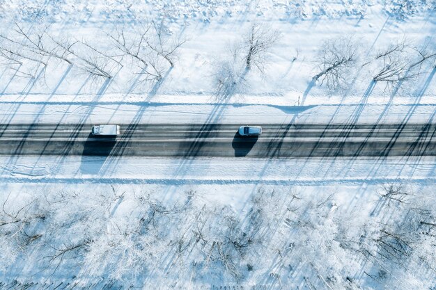 Foto veduta aerea della strada invernale con un'auto e alberi innevati paesaggio invernale