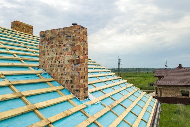 Aerial view of a wooden roof frame of brick house under construction.