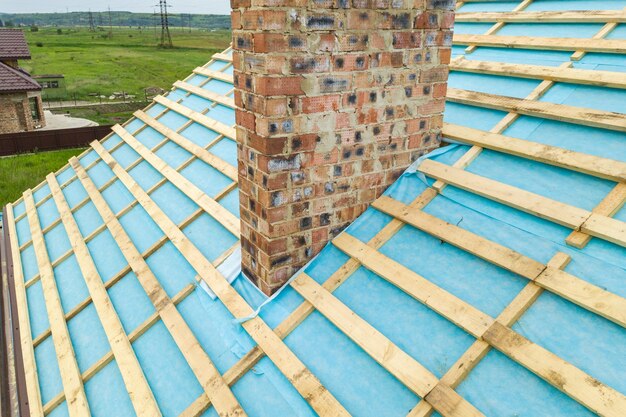 Aerial view of a wooden roof frame of brick house under construction.