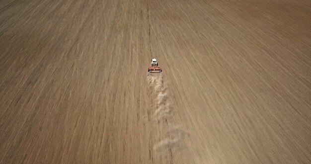 Aerial view the work of the tractor in the field. Sowing crops in the spring.