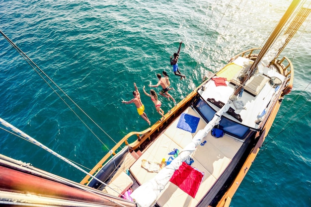 Aerial view of young people jumping from sailing boat on sea
trip