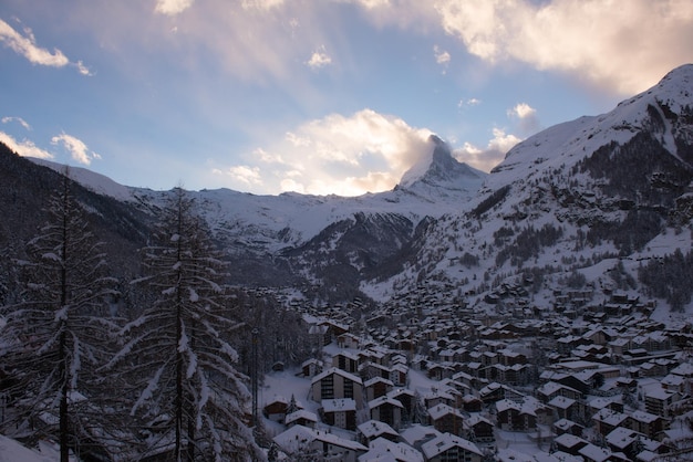 スイスの新雪を積んだ夕暮れ時のツェルマット渓谷とマッターホルン山頂の空撮