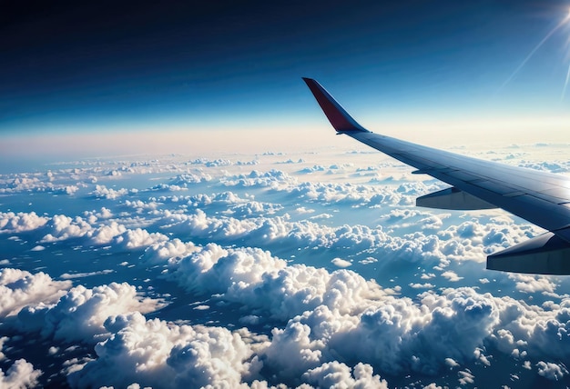 空の雲の上を飛ぶ飛行機の翼の窓からの空中眺め