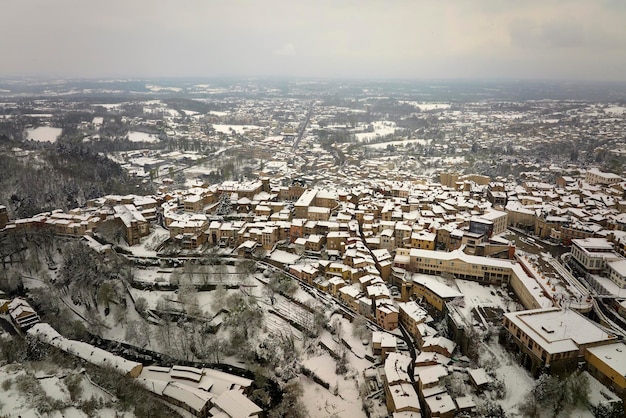 Paesaggio invernale aereo del centro storico denso della città di thiers nel dipartimento di puydedome regione auvergnerhonealpes in francia tetti di vecchi edifici e strade strette a nevicate