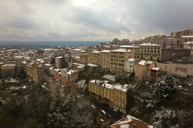 Aerial winter landscape of dense historic center of Thiers town in PuydeDome department AuvergneRhoneAlpes region in France Rooftops of old buildings and narrow streets at snowfall