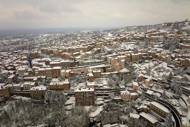 Aerial winter landscape of dense historic center of Thiers town in PuydeDome department AuvergneRhoneAlpes region in France Rooftops of old buildings and narrow streets at snowfall