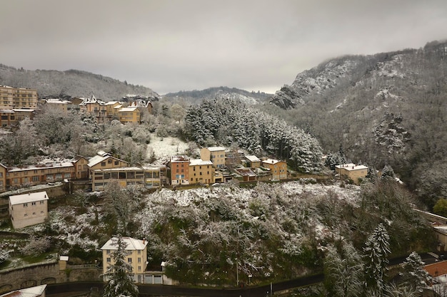 Aerial winter landscape of dense historic center of Thiers town in PuydeDome department AuvergneRhoneAlpes region in France Rooftops of old buildings and narrow streets at snowfall