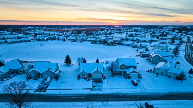 Foto suburbio invernale aereo al crepuscolo case coperte di neve scena tranquilla