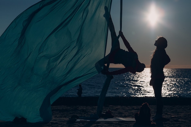 Photo aerial yoga on the beach. healthy woman.