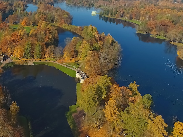 Аэрофотоснимок парка осенью. Вид на озеро и лес сверху. Гатчина. Россия