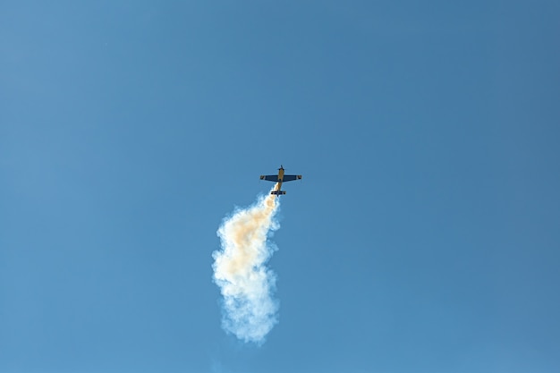 The aerobatic plane with smoke track in the sky