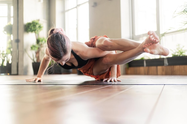 An aerobics coach does exercises for body flexibility A strong woman does a fitness and yoga workout