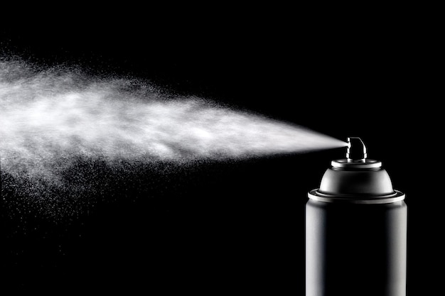 An aerosol can of spray dispensing its content against a backlit black background