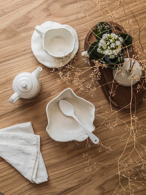 Foto impostazione della colazione estetica stoviglia in ceramica coppia di ciotole di tè decorazione di teiera su una tavola in legno vista superiore
