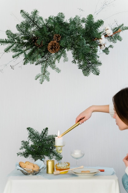 Aesthetic design for christmas with pine nobilis hanging garland, candles and table decorations