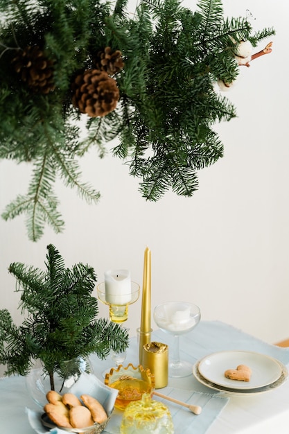 소나무 nobilis 매달려 화환, 양초 및 테이블 장식으로 크리스마스를위한 미적 디자인.