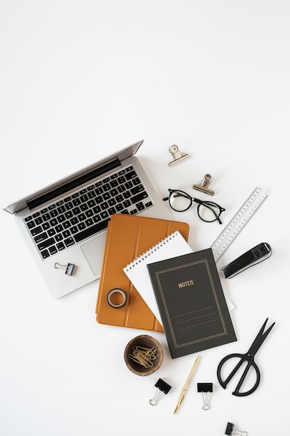 Premium Photo  Gold styled modern home office desk with notebook, scissors  and clips on white surface