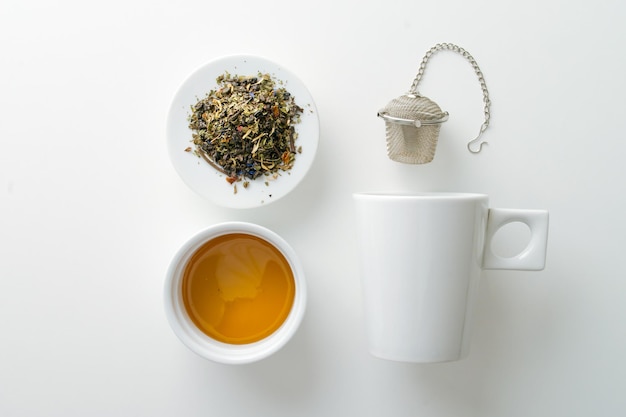Эстетическое изображение травяного чая, металлического чайника, кружки и меда на белом фоне