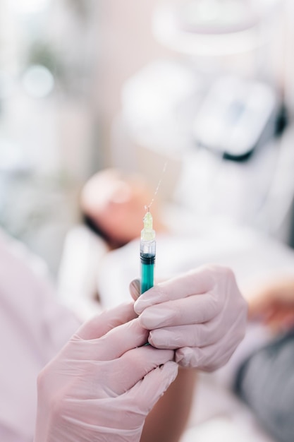 Aesthetic medicine doctor preparing syringe for injection in beauty salon