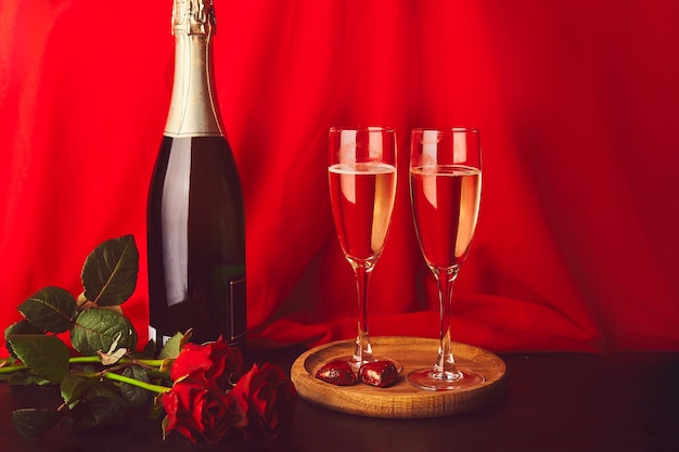 Aesthetic romantic Valentine background red roses champagne glasses candies Copy space