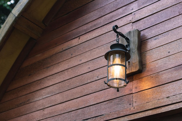 Photo aesthetic rustic wall lamp on facade of a house with wooden wall