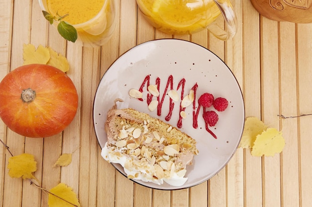 Aesthetic vegan pumpkin cake with healthy sea buckthorn tea Vegan breakfast at the terrace Natural healthy lunch among autumn leaves