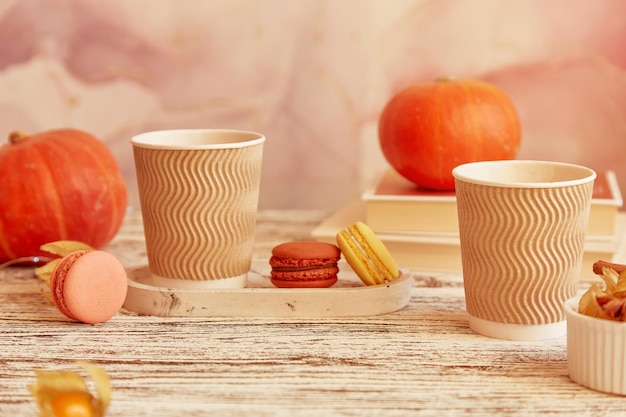 Aesthetics cardboard cups with pumpkin latte Seasonal couple breakfast with coffee and macaroons