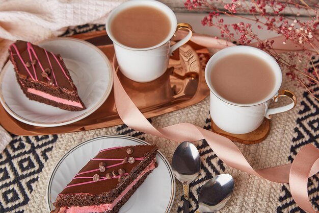 Aesthetics delicate St Valentines day breakfast with chocolate cherry cake pieces rhombus coffee cups among decorations