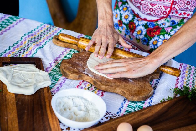 afbeelding met de handen van een dame die traditionele Roemeense gebakken taarten met kaas kookt