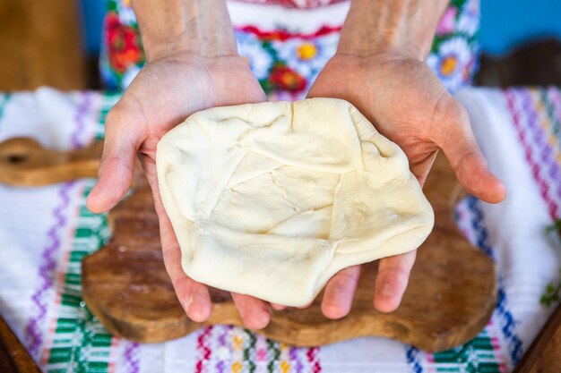 afbeelding met de handen van een dame die traditionele Roemeense gebakken taarten met kaas kookt