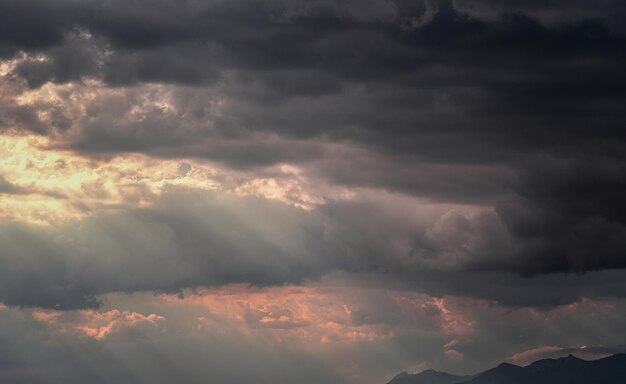 Afbeelding met wolken voordat het 's middags gaat regenen en bergen op de achtergrond