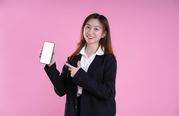 Afbeelding van Aziatische zakenvrouw met behulp van telefoon op roze achtergrond