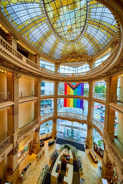 Foto afbeelding van de lege lobby van rotunda met een plafond van glas-in-lood en een regenboogvlag die buiten de ramen bungelt