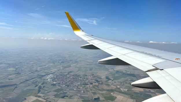 Afbeelding van de vleugel van een vliegtuig terwijl het door de lucht vliegt