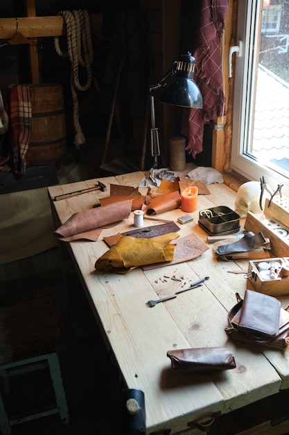 Afbeelding van de werkplek van een schoenmaker met gereedschap erop die zich voorbereidt op het werk