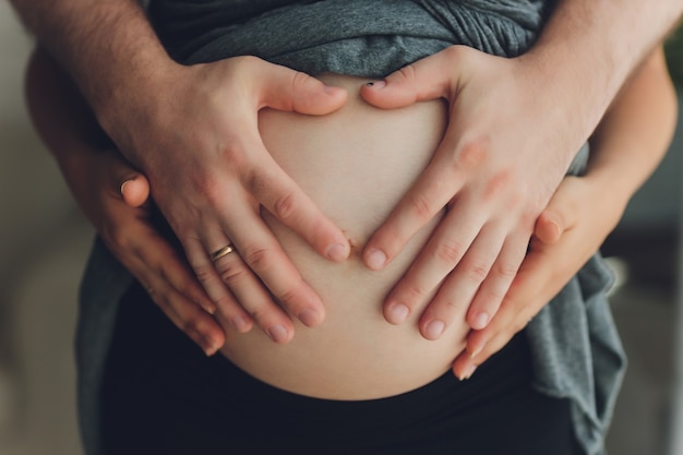 Afbeelding van de zwangere vrouw haar buik met handen aan te raken.