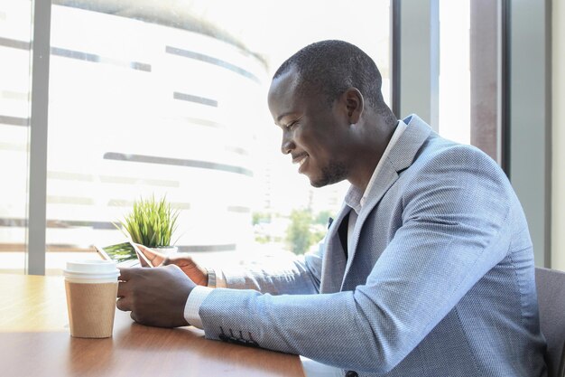Afbeelding van een Afro-Amerikaanse zakenman die aan zijn touchpad werkt