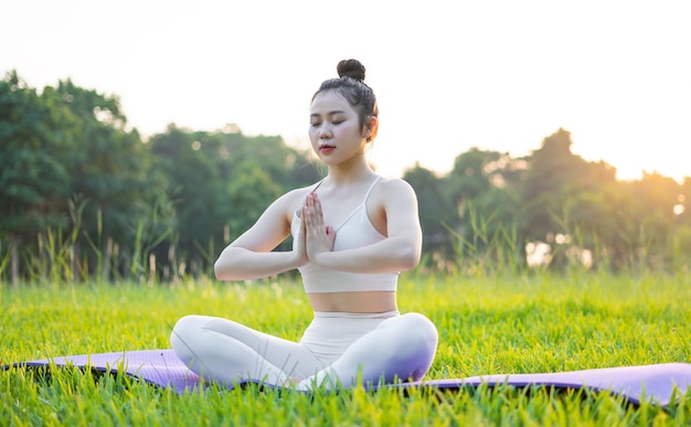 Afbeelding van een Aziatische vrouw die buiten yoga doet